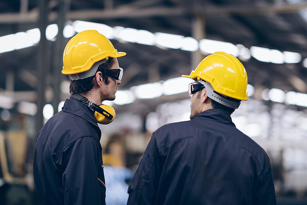 Maintenance engineers assessing operations and routine inspections in a factory.
